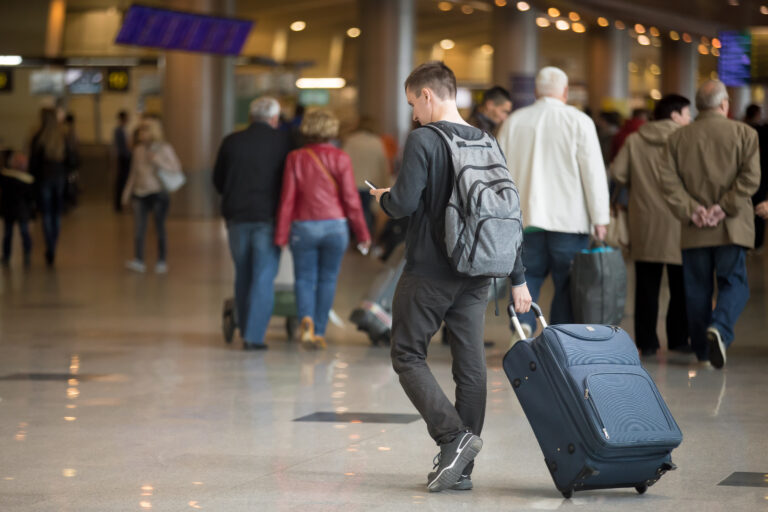 Young,Handsome,Traveler,In,20s,Walking,In,Modern,Airport,Terminal,