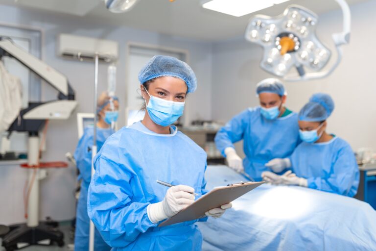 Surgeon,Writing,On,Clipboard,In,Operation,Room,,Anaesthesiologist,Writing,The