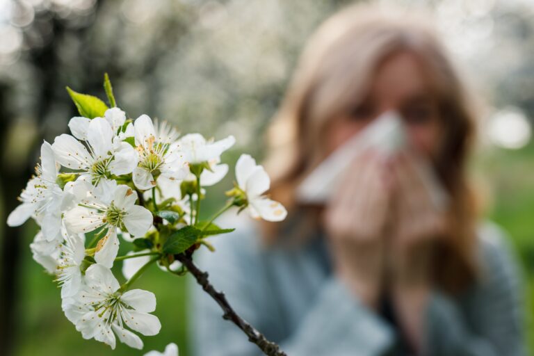 Woman,Sneezing,And,Blowing,Nose,In,Blooming,Park.,Spring,Pollen