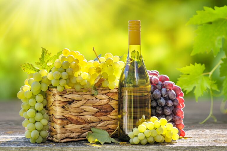 Bottle,Of,White,Wine,And,Basket,Of,Grape,In,Front
