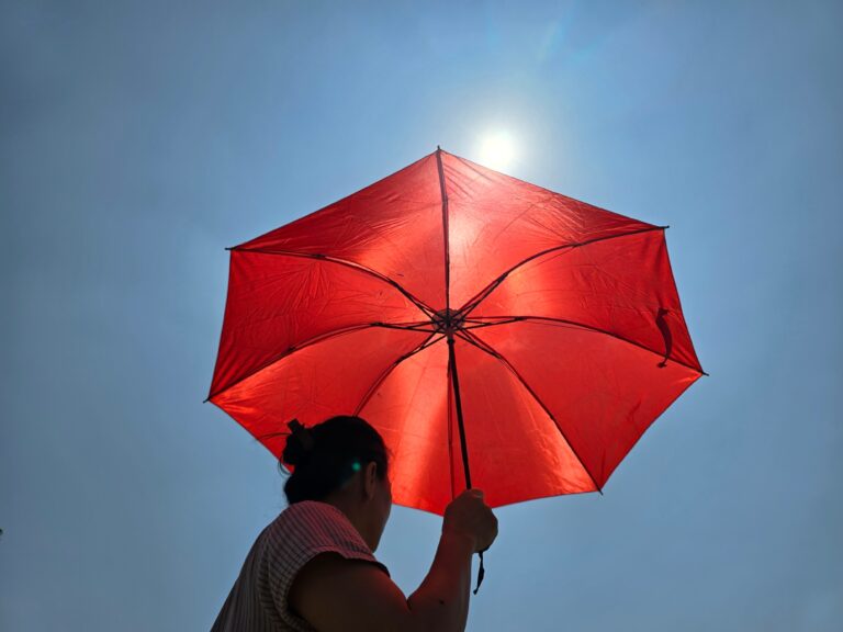 Asian,Woman,With,Red,Umbrella,Walking,Outdoors,In,Hot,Weather