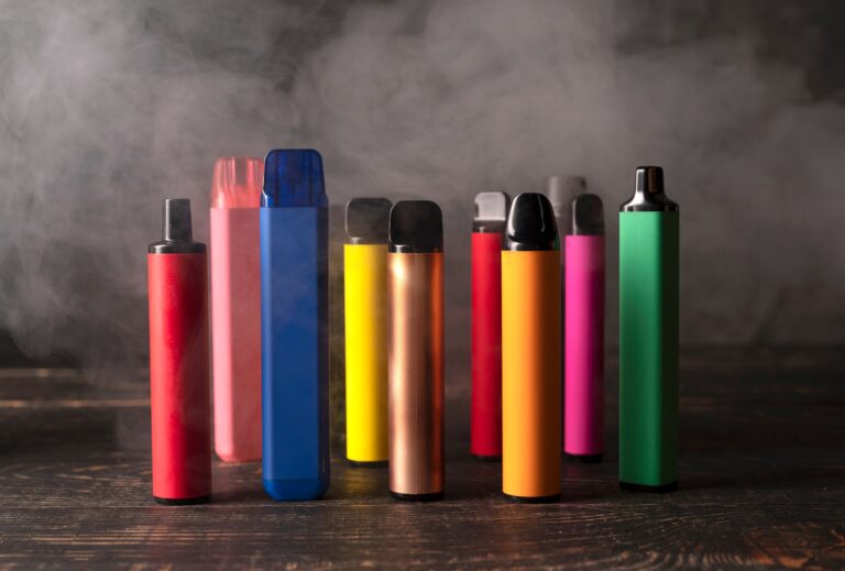 Set,Of,Colorful,Disposable,Electronic,Cigarettes,On,A,Dark,Wood
