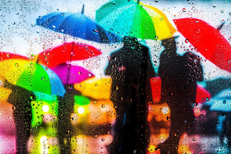 View,Through,Glass,Covered,With,Raindropson,As,Teenagers,Playing,In