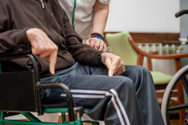 Caregiver,Assisting,Elderly,Man,In,Dining,Room,At,Nursing,Home.