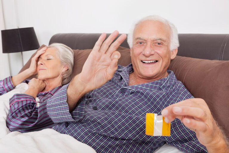 Portrait,Of,Excited,Elderly,Man,Holding,Torn,Condom,Packet,While