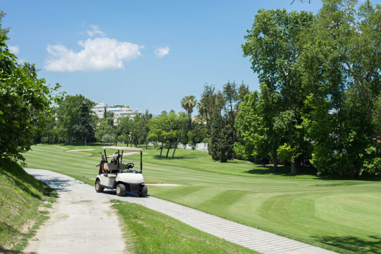 Buggy,At,Golf,Course,With,Blue,Sky.