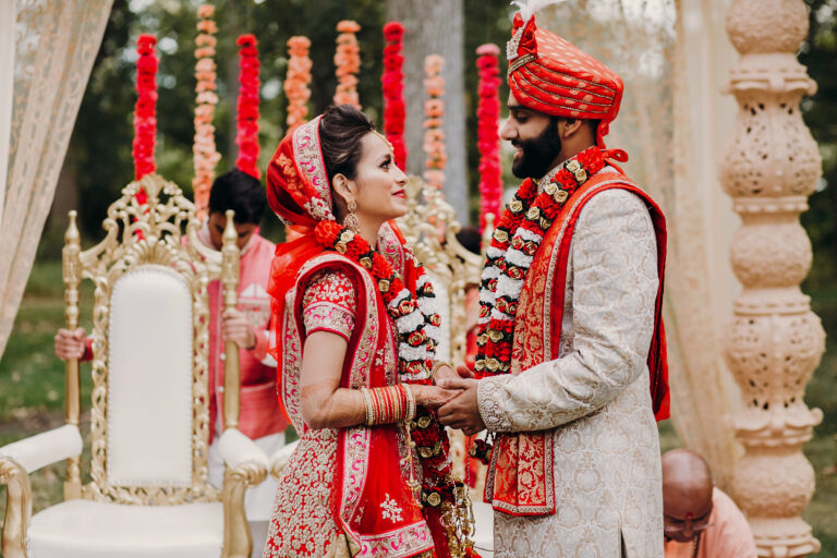 Indian,Groom,Dressed,In,White,Sherwani,And,Red,Hat,With