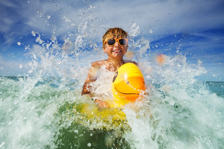 Happy,Boy,In,Orange,Sunglasses,With,Yellow,Inflatable,Duck,Play