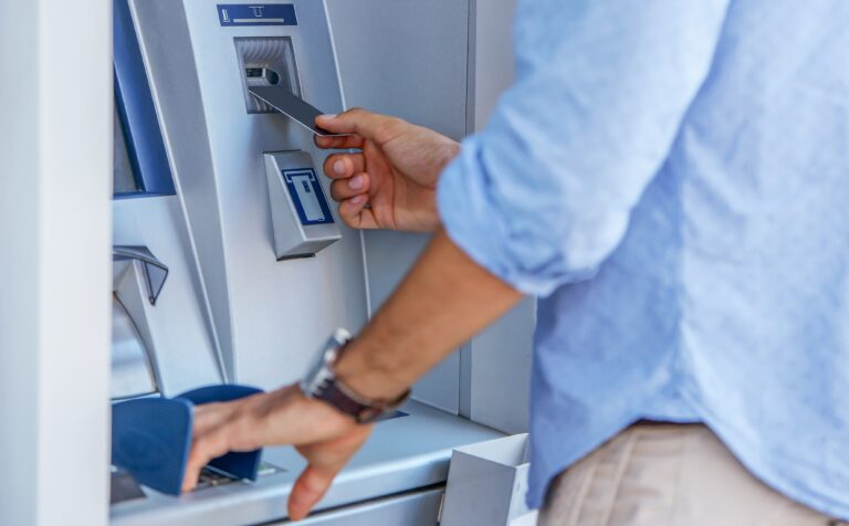 Man,Using,A,Street,Atm,Machine,And,Withdrawing,Money,,Close