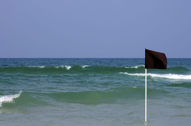 Black,Warning,Flag,In,Shallow,Water