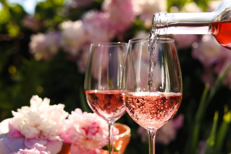 Pouring,Rose,Wine,Into,Glass,In,Garden,,Closeup