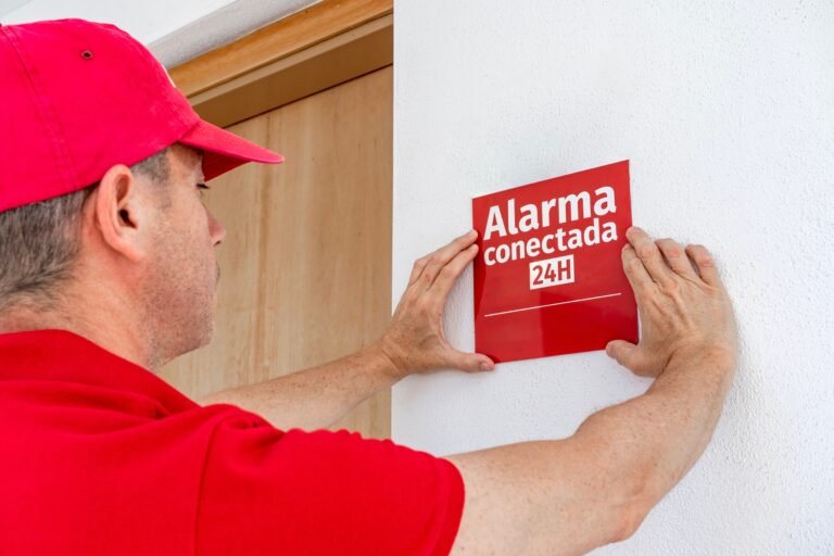 Technician,Installing,An,Alarm,Warning,Sign,In,Spanish,On,The