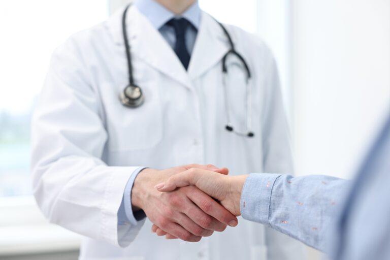 Doctor,Shaking,Hands,With,Patient,In,Clinic,,Closeup