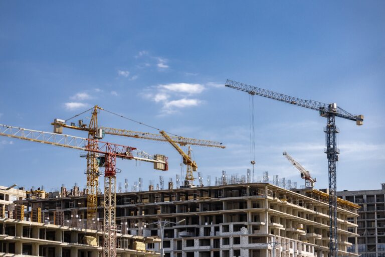 Crane,On,Construction,On,Blue,Sky,Background.,Tower,Cranes,In