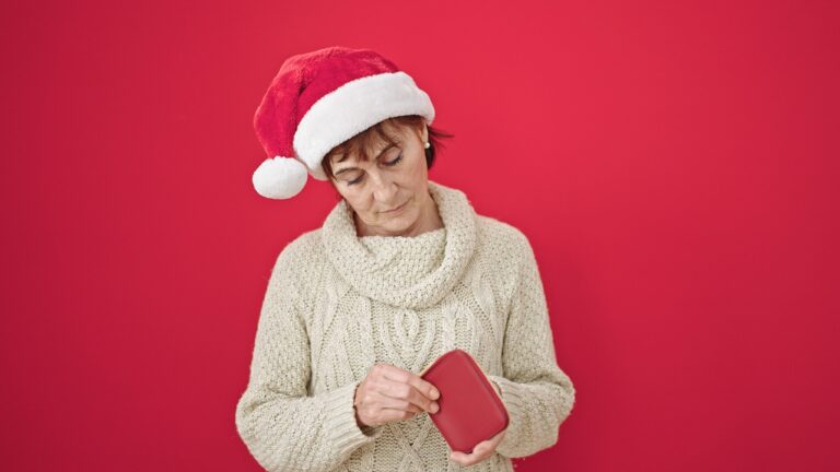 Mature,Hispanic,Woman,Wearing,Christmas,Hat,Looking,Into,Empty,Wallet
