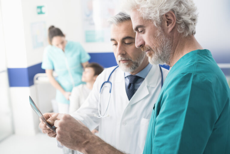 Confident,Professional,Doctors,Examining,A,Patient's,X-ray,And,Woman,On