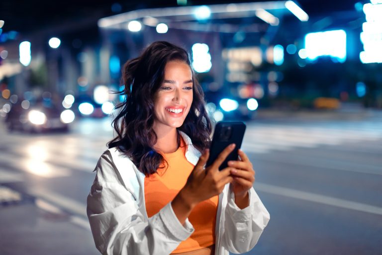 Techno,Night,Walks.,Smiling,Woman,Holding,Smartphone,,Reading,Message,While