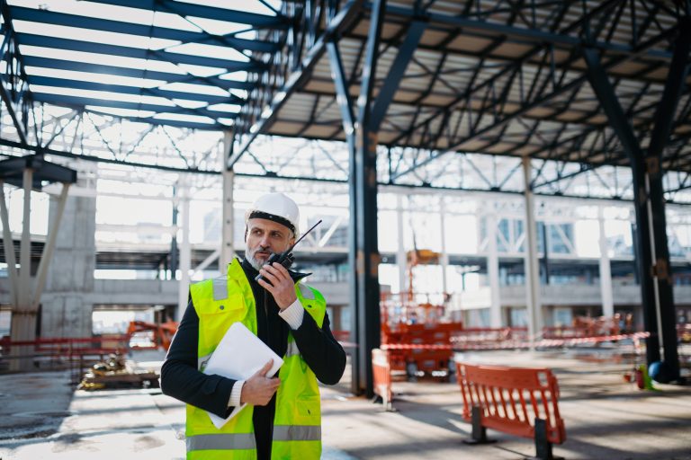 Construction,Foreman,Giving,Instructions,Over,Radio,During,Building,Inspection.