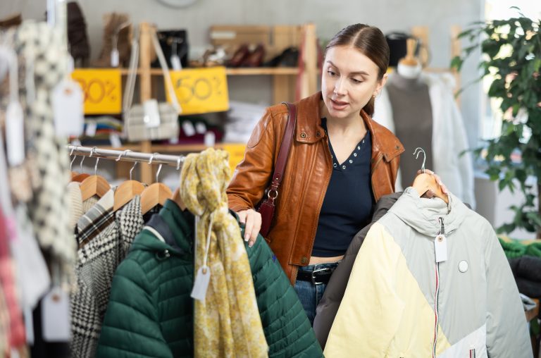 Stylish,Young,Woman,Standing,In,Modern,Clothing,Shop,And,Looking