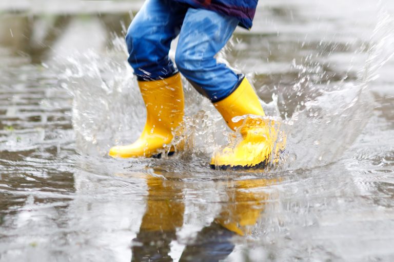 Close-up,Of,Kid,Wearing,Yellow,Rain,Boots,And,Walking,During
