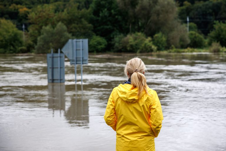 Flooded,River.,Worried,Woman,Looking,At,Overflowing,Water,During,Flood.